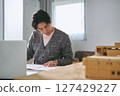A male architect working seriously in front of models and drawings in an architectural design office 127429227