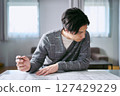 A male interior coordinator thinking about interior design while looking at a building blueprint 127429229
