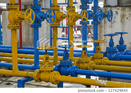 Understanding Gas Plant Safety: Blue and Yellow Pipe and Valve Systems 127429645