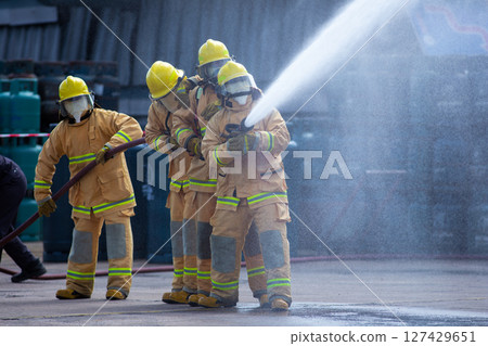 Teams of Firefighters Spray Water to Tame the Fire 127429651
