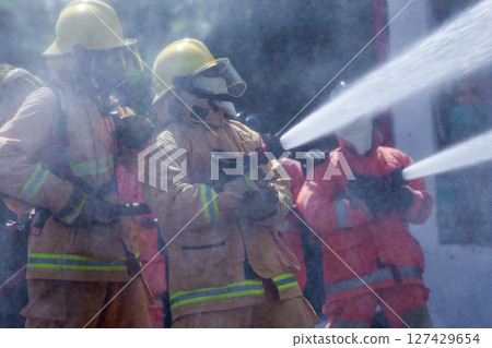 Teams of Firefighters Spray Water to Tame the Fire 127429654