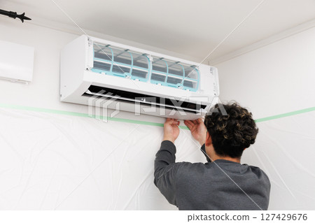A worker installing an air conditioner 127429676