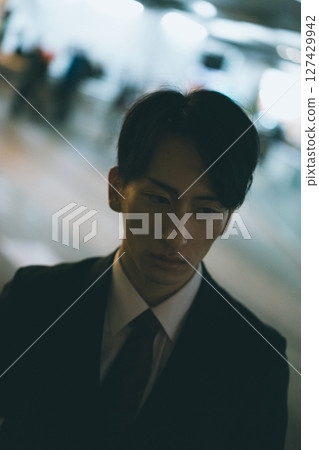 一位年輕的男性商人晚上趕回家 127429942