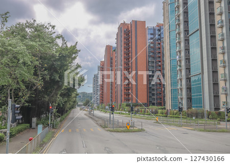June 7 2025 Urban Street with Modern Buildings and Greenery on a Cloudy Day 127430166