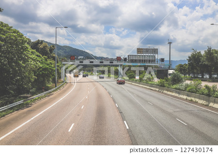 June 7 2025 Highway Traffic in a Green Landscape Under a Cloudy Sky 127430174