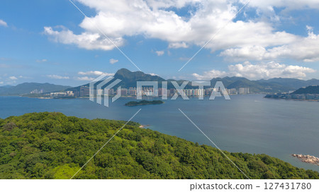 View of Forested Island Surrounded by Coastal City and Mountains View of Forested Island Surrounded by Coastal City and Mountains 127431780