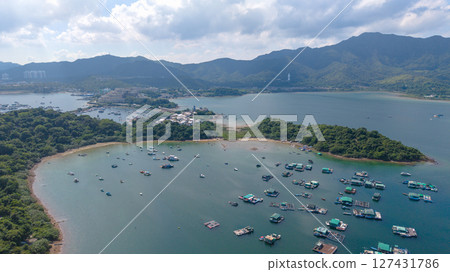 Scenic Coastal Landscape with Buildings Against Green Hills 127431786