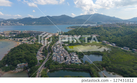Landscape of Coastal Town Surrounded by Hills and Tranquil Waters 127431812