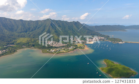 View of a Coastal Village with Surrounding Mountains and Clear Waters View of a Coastal Village with Surrounding Mountains and Clear Waters 127431833
