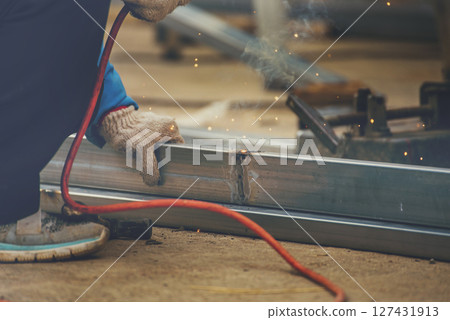 Men hands wear protective glove Hot flame metal work cutting fire iron workshop. Locksmith use Welding machine cut metal process. Construction Worker hands using Welding machinery iron metal sparking 127431913