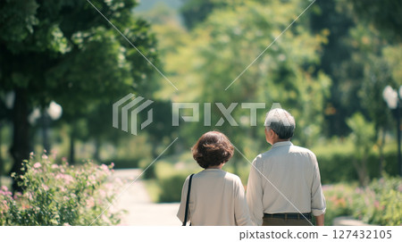 Back view of an elderly couple walking in a park full of greenery Back view of an elderly couple walking in a park full of greenery 127432105