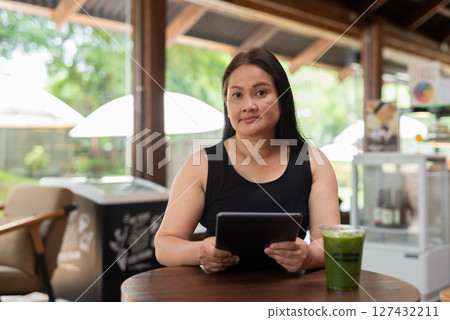 Mature Asian woman sitting in coffee shop 127432211
