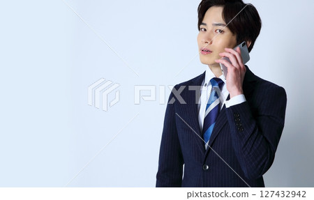 一位時尚商人手持智慧型手機的圖片 一位時尚商人手持智慧型手機的圖片 127432942