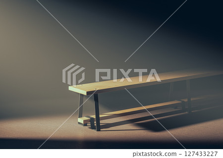 Soccer ball is sitting on the ground next to a bench 127433227