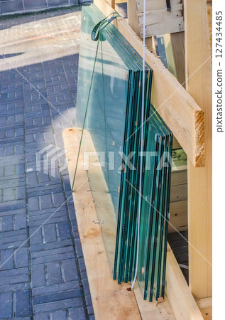 Sheets of glass stacked vertically in wooden construction frame. High quality photo 127434485