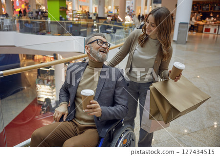 A joyful mall outing with a wheelchair user and companion, highlighting their fun experience 127434515