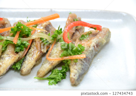 Small mackerel marinated in nanbanzuke (pickled vegetables) on a plate 127434743