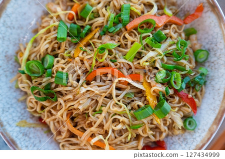 Delicious Asian Noodle Dish with Vibrant Vegetables, a Culinary Delight, and Fresh Herbs 127434999