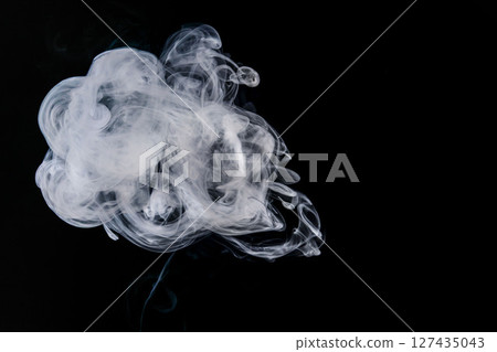 Steam floating in front of a black background Steam floating in front of a black background 127435043