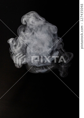 Steam floating in front of a black background 127435048