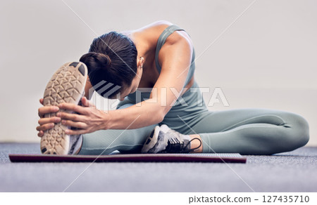 Yoga, fitness and stretching woman on floor for body wellness, exercise and healthy lifestyle with wall mockup for marketing. Sports athlete girl with foot or sneakers in cardio, pilates and workout 127435710