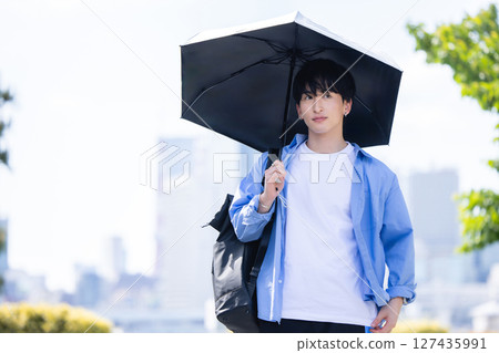 A man holding a parasol 127435991