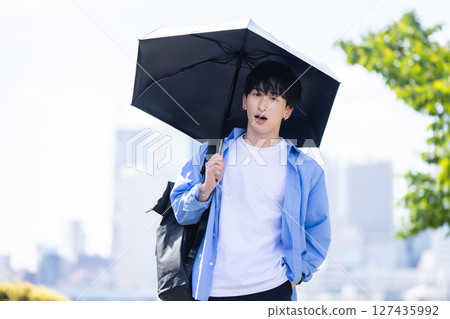 A man holding a parasol 127435992