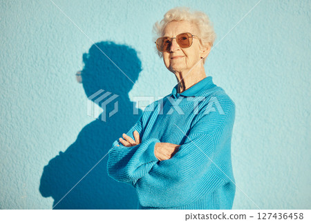 Fashion, sunglasses and portrait of old woman with arms crossed on wall background for stylish, cool and unique aesthetic. Retirement, beauty and elderly female model with designer brand glasses. 127436458