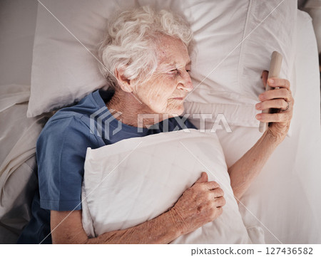 Bad vision, senior woman and phone on bed in bedroom home texting, social media or internet browsing. Blurred eyesight, retired and elderly female with smartphone squinting and trying to read message Bad vision, senior woman and phone on bed in bedroom home texting, social media or internet browsing. Blurred eyesight, retired and elderly female with smartphone squinting and trying to read message 127436582