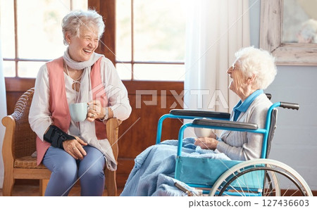 Disabled senior woman, friends and coffee with smile, funny conversation or talking with laugh, wheelchair or happy. Elderly women, drinking tea ort enjoy communication, joke and bond in retirement 127436603
