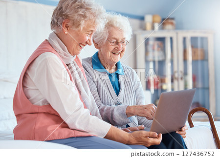 Senior women, friends and laptop in home for social media, watching movie or video call. Tech, computer and happy elderly retired females streaming video or internet browsing while talking together. Senior women, friends and laptop in home for social media, watching movie or video call. Tech, computer and happy elderly retired females streaming video or internet browsing while talking together. 127436752