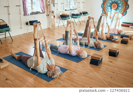 Yoga, stretching and senior women training body for health, exercise and fitness on the floor of a gym. Wellness, relax and group of elderly friends in a workout class for pilates and rehabilitation 127436921