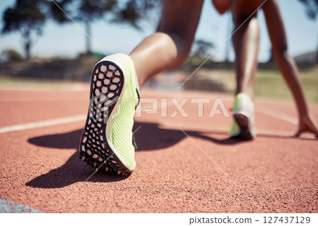 Runner, start race and closeup feet, legs or ready for competition, contest or sport event in sunshine. Athlete, training and running in position for fast speed on ground for success in summer run 127437129