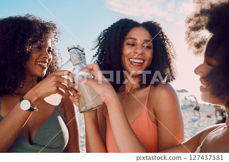 Summer, cheers and group of friends at the beach enjoying vacation, holiday and weekend adventure. Travel, friendship and black women toast to celebrate with alcohol drink on sand by ocean together 127437381