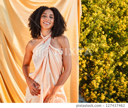 Beauty, fashion and portrait of black woman in garden on outdoor shoot with silk fabric backdrop and plants in summer sun. Elegance, glamour and happy woman with afro, smile and nature in background. Beauty, fashion and portrait of black woman in garden on outdoor shoot with silk fabric backdrop and plants in summer sun. Elegance, glamour and happy woman with afro, smile and nature in background. 127437462