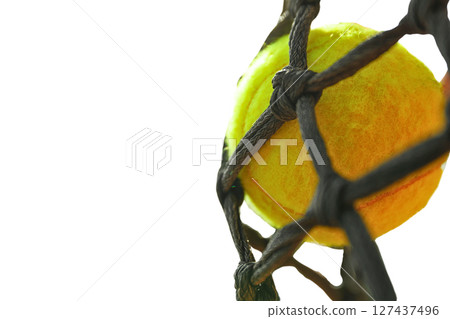 Bright yellow tennis ball entangled in netting, isolated on white 127437496