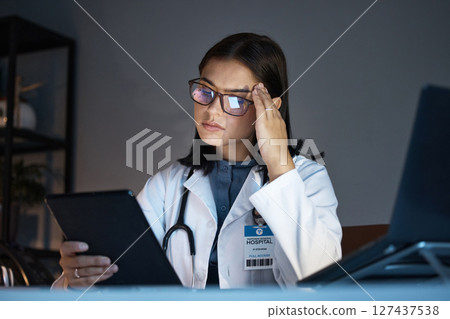 Woman, healthcare doctor and stress or headache on tablet for research in medical hospital. Young girl, pharmacist and burnout or health fatigue problem at night with mental health and digital device 127437538