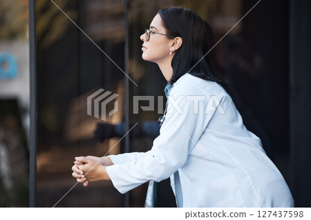 Healthcare, idea and balcony with a doctor woman thinking while working at the hospital for medical or insurance. Health, treatment and contemplation with a female medicine professional at work 127437598