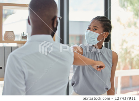 Business people, covid and elbow greeting for social distance or health and safety during pandemic at the office. Man and woman employee elbow bump with face masks for workplace rules and regulations Business people, covid and elbow greeting for social distance or health and safety during pandemic at the office. Man and woman employee elbow bump with face masks for workplace rules and regulations 127437911