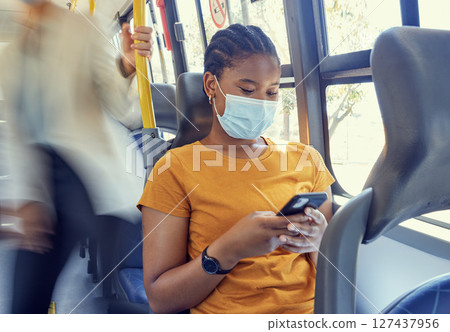 Bus travel, covid and black woman, smartphone and social media, reading notification and 5g online mobile tech on transportation. Young girl, face mask and corona virus safety with cellphone on metro 127437956