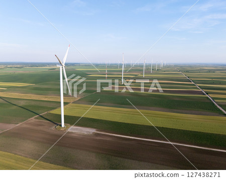 Aerial view of wind turbines on an agricultural filed at sunset. 127438271