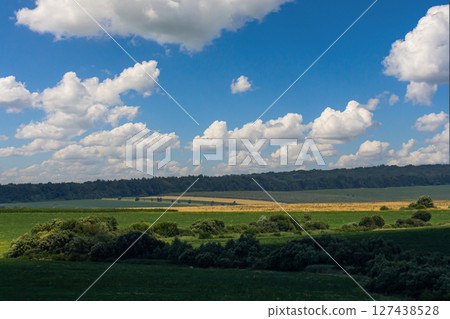 Cloud formation resembling a heart shape over a green landscape during daytime in the countryside 127438528