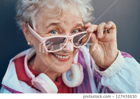 Face portrait and senior woman with sunglasses, headphones and vintage clothing. Fashion, beauty and happy, retired and elderly female in retro, cool and pink designer glasses and outfit with smile. Face portrait and senior woman with sunglasses, headphones and vintage clothing. Fashion, beauty and happy, retired and elderly female in retro, cool and pink designer glasses and outfit with smile. 127438830