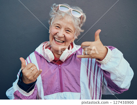 Shaka sign, portrait and senior woman in retirement standing by gray wall with a smile or happiness. Happy, fun and friendly elderly lady pensioner in the outdoor city with a hang loose hand gesture. 127438900