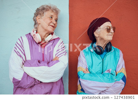 Fashion, headphones and senior women in city with blue and red wall background model for urban style. Freedom, music and elderly females relax on weekend in trendy, cool and modern outfit in town 127438901