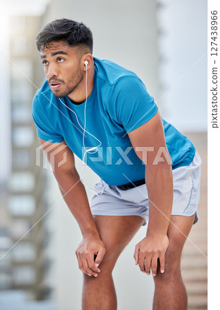 Tired, fitness and sweat with earphones music for cardio, workout and athletic training break. Exercise, exhausted and sweaty indian man listening to audio streaming on outdoor athlete rest. Tired, fitness and sweat with earphones music for cardio, workout and athletic training break. Exercise, exhausted and sweaty indian man listening to audio streaming on outdoor athlete rest. 127438966