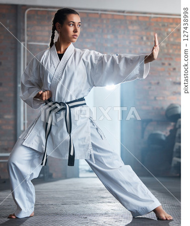 Karate training, fitness and woman in gym, healthcare motivation and strong focus for fight workout. Fist, sport exercise and healthy athlete person or martial arts wellness for taekwondo competition 127438998