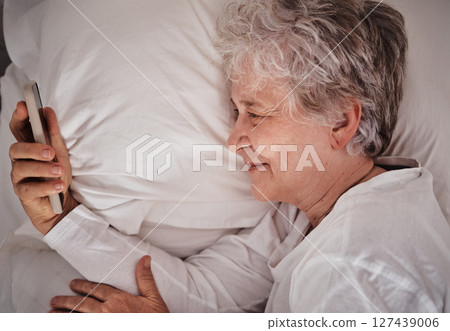 Smile, phone and senior woman in bed, text and read social media, message and relax in her home. Happy, elderly lady and online communication after wake up, browse and email on smartphone in bedroom Smile, phone and senior woman in bed, text and read social media, message and relax in her home. Happy, elderly lady and online communication after wake up, browse and email on smartphone in bedroom 127439006