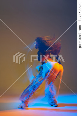 Group of dancers executing jazz-funk routines in a contemporary studio setting, highlighting expressive movements and coordinated energy. 127439098