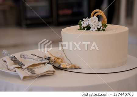Elegant Wedding Cake with White Floral Decoration on Round Table, Light Beige and Cream Color Palette, Celebration and Dessert Theme. 127440763